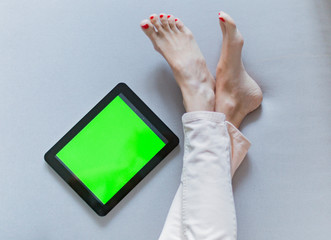young woman reading a tablet green screen