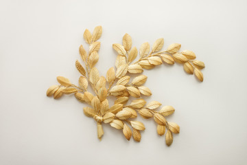 Decoration of straw on a white background. The branch with leaves is made of straw. Straw wall decoration Decor. The products are made of straw