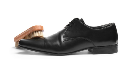 Stylish men's shoe and cleaning brush on white background