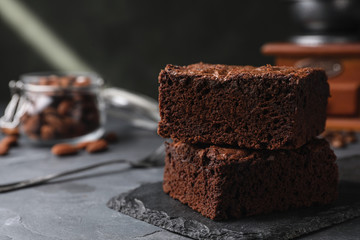 Slate board with fresh brownies on grey table, space for text. Delicious chocolate pie