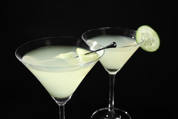 Glasses of delicious cucumber martini on dark background