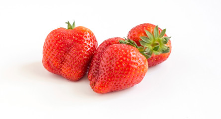 three large red ripe strawberries on white background
