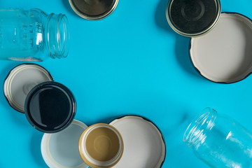 Recycling glass jar lids; Reuse of single use items; Zero no waste recycle program campaigns; Recyclable concept on blank empty copyspace, text room space for copy on horizontal light blue background.