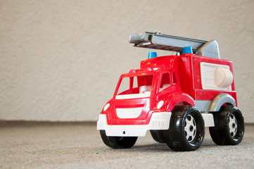 Children's toy. Old plastic fire truck. On the floor