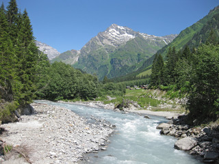 torrential glacier milk river on a sunny day making its way to the valley