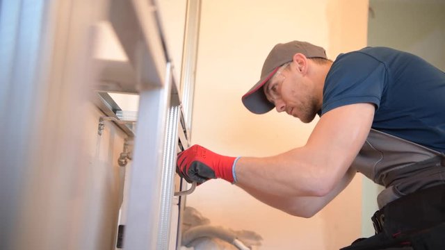 Caucasian Sanitary Plumbing Installer in His 30s Installing Bathroom Equipment.