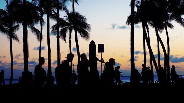 Tourists walking at sunset in Waikiki beach in 4k