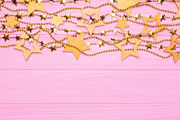 Flat lay border of big and small stars of confetti. Golden beads stars
