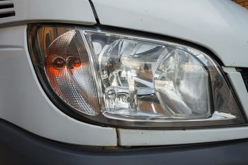 The dirty headlights of a car. Close-up