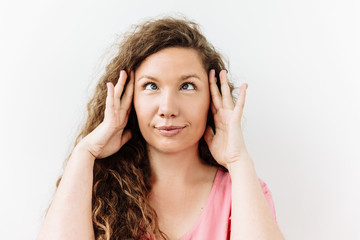 Making face, funny foolishes portrait of  curly crossed eyes woman, against white background.