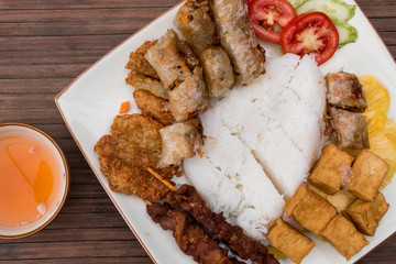 Bun Cha, traditional vietnamese food. Spring rolls with tofu, rice, pork steak, salad and pineapple.