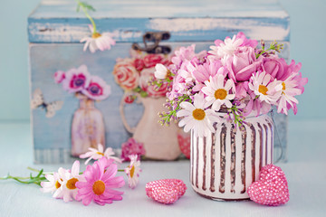 Lovely bunch of flowers .Beautiful fresh roses flowers in a box decorated with a heart on a pink background with texture .