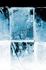 Naklejka na ściany i meble Textured frosty crystal clear ice blocks isolated on black background.