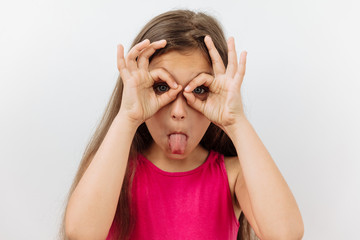 Making face,funny  foolishes portrait of 9 year girl ,against white background.