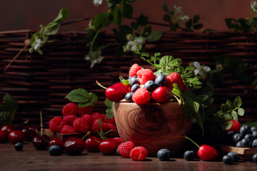 Berries closeup colorful assorted mix of strawberry, blueberry, raspberry and sweet cherry on a old wooden table.