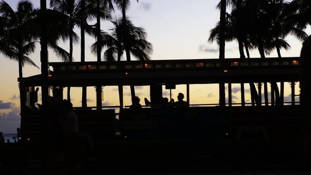 Tourists walking at sunset in Waikiki beach in 4k