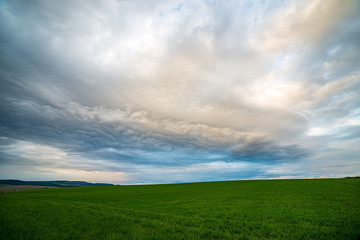 countryside landscape under blue sky and dramatic white clouds