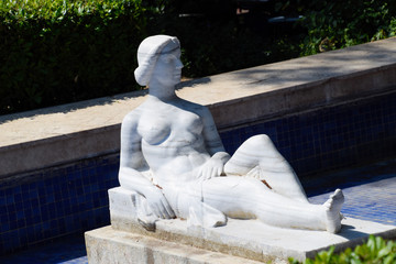 Modern marble statue, nude woman statue in a fountain.