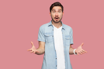 How you did this? Portrait of shocked sad bearded young man in blue casual style shirt standing...