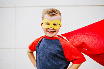 Little boy wearing cape dressed up like a superhero