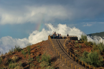 rainbow over the forest, the phenomenon of nature, rocks and trees, bright colors on the rainbow, rain and cloudy sky