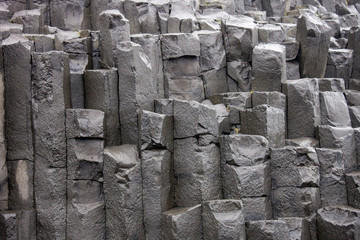 Black basalt columns of Reynisfjara look like huge pencils, a world-famous black-sand beach found...