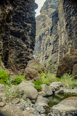 Rocks in the Masca gorge, Tenerife, showing solidified volcanic lava flow layers and arch formation. The ravine or barranco leads down to the ocean from a 900m altitude.