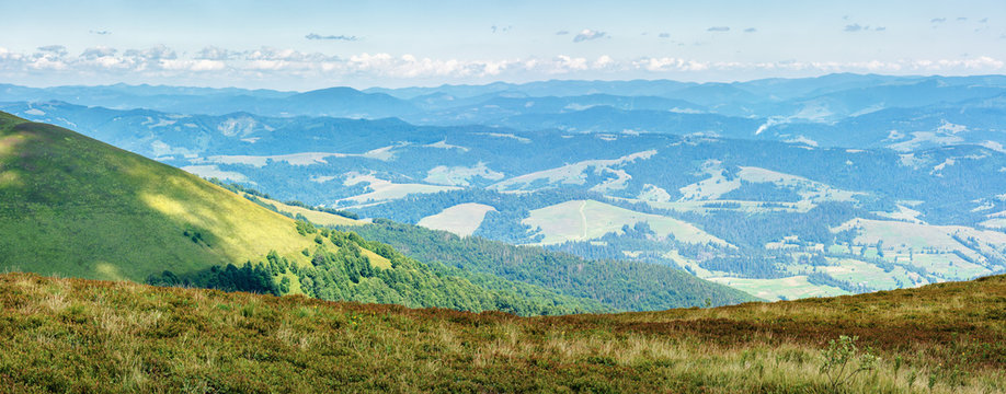 panorama of a mountain landscape. beautiful view in to the valley from the top of a hill. sunny weather with clouds on the sky in summertime