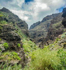 Fototapeta na wymiar Rocks in the Masca gorge, Tenerife, showing solidified volcanic lava flow layers and arch formation. The ravine or barranco leads down to the ocean from a 900m altitude.