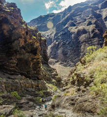 Rocks in the Masca gorge, Tenerife, showing solidified volcanic lava flow layers and arch formation. The ravine or barranco leads down to the ocean from a 900m altitude.