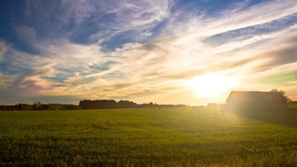 Obraz premium Coucher de soleil et nuage au-dessus d'un champ avec une vieille grande en bois rustique