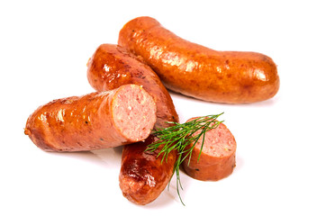 Grilled dill sausages on a light background.Fried pork sausages with greens in a pile on a white background.