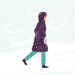 Fototapeta na wymiar Girl in winter coat walking through cold wind and snow blizzard