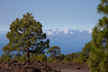 Island of La Gomera, partly covered by the clouds. Bright blue sky. View from 1900 meters of altitude. Teide National Park, Tenerife, Canary Islands, Spain.