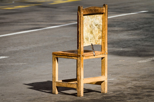 Old Wooden Chair In The Middle Of The Road