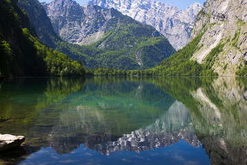 Fototapeta na wymiar lake with crystal clear water in the spring mountains. A small lake in the Alps view from one shore. Reflection of mountains in the water of alpine lake