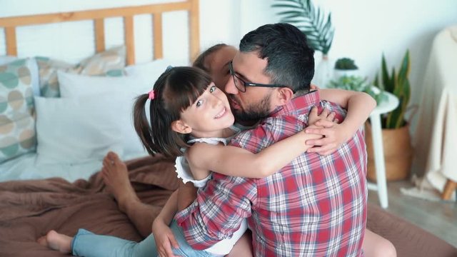 Dad hugs and kisses his daughters, girls love dad, slow motion