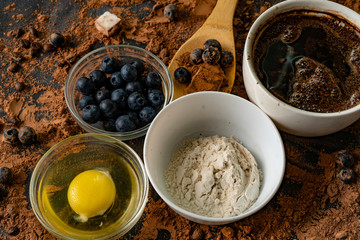 top view of ingredients for cooking or baking chocolate on the table, blueberry, egg, flour, cocoa and chocolates