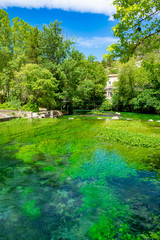 South of France, view on small Provencal town of poet Petrarch Fontaine-de-vaucluse with emerald green waters of Sorgue river