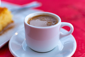 Traditional greek coffee served in white coffee set in cafe