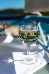 White wine served outside on balcony on glass table with sea view