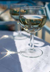 White wine served outside on balcony on glass table with sea view