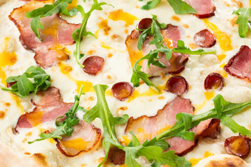 Pizza with ham , arugula (salad rocket), rucola and mozzarella  on  wooden background close up. Italian cuisine.
