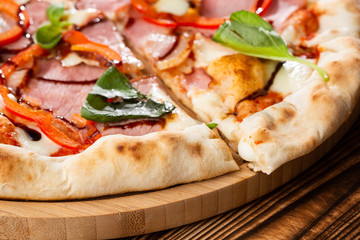 Pizza on wooden background, top view. Pizza with pepper, ham,  Basil and Mozzarella Cheese close up. Flyer and poster for Restaurants or pizzerias, template with delicious taste  pizza.