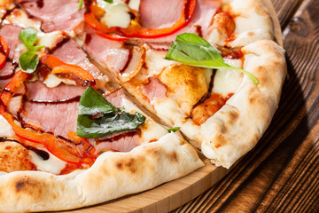 Pizza on wooden background, top view. Pizza with pepper, ham,  Basil and Mozzarella Cheese close up. Flyer and poster for Restaurants or pizzerias, template with delicious taste  pizza.