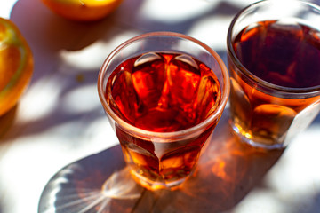 Young rose wine served outside in garden on white table with fresh orange in sun lights