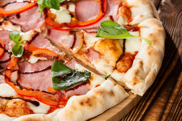 Pizza on wooden background, top view. Pizza with pepper, ham,  Basil and Mozzarella Cheese close up. Flyer and poster for Restaurants or pizzerias, template with delicious taste  pizza.