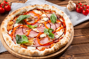 Pizza on wooden background, top view. Pizza with pepper, ham,  Basil and Mozzarella Cheese close up. Flyer and poster for Restaurants or pizzerias, template with delicious taste  pizza.