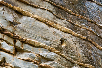 Abstract background with golden color mineral rock texture close up