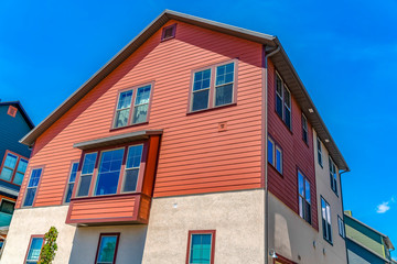 Exterior of home with a combination of red wood section and neutral wall